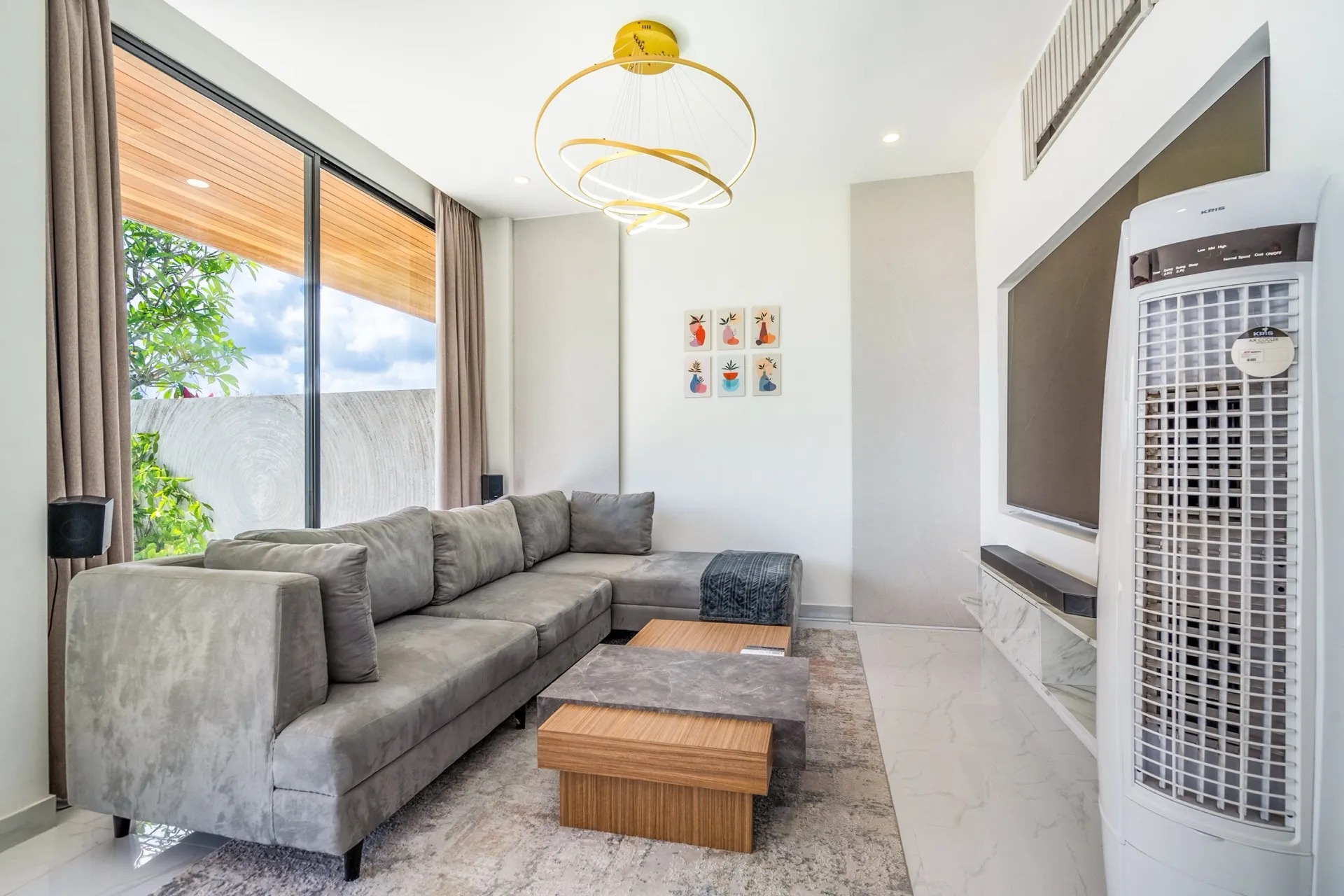 Villa Maisie's living room, a grey sectional sofa beneath a brass ring pendant